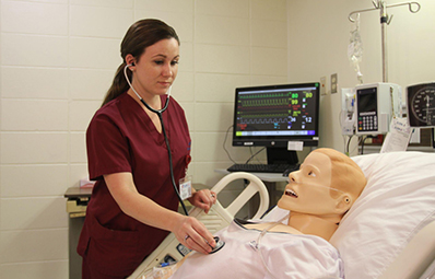 nursing student in mock hospital room.