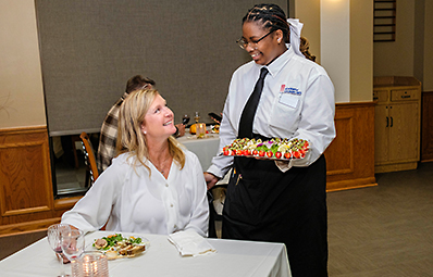 Culinary students server a prepared dish from Careme's.