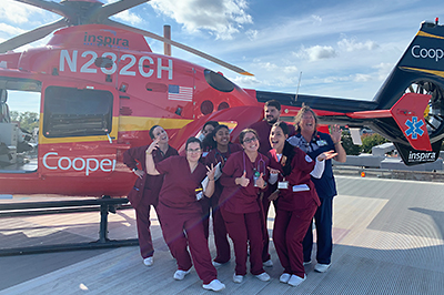 Nursing students on a heli pad in front of an med vac helicopter