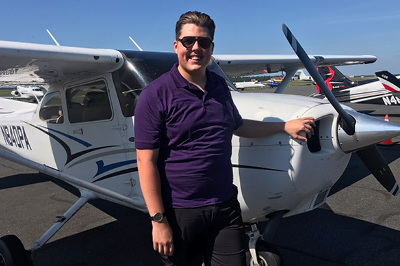 male pilot in front of a small plane