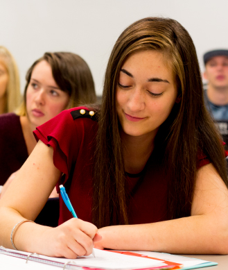 female student taking notes in class