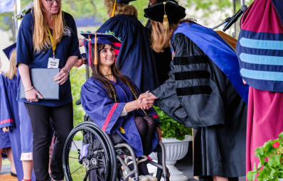student in wheelchair receiving diploma