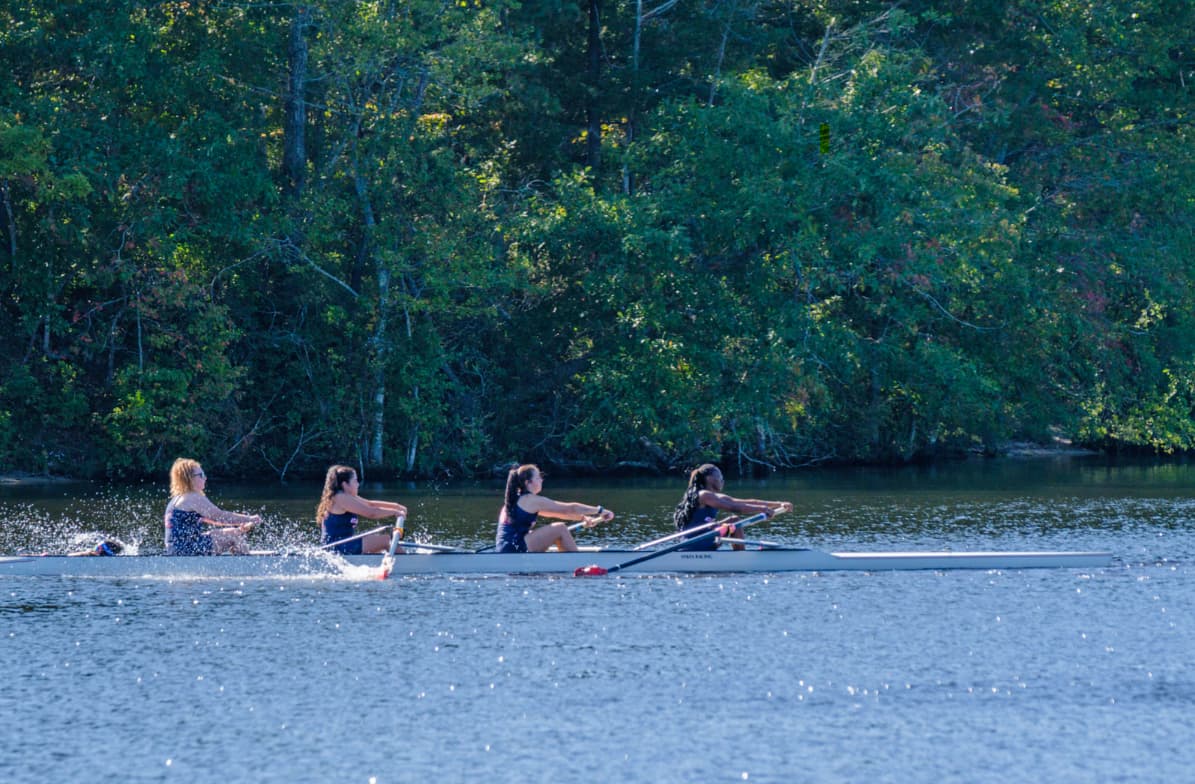 Atlantic team rowers on lake near woods