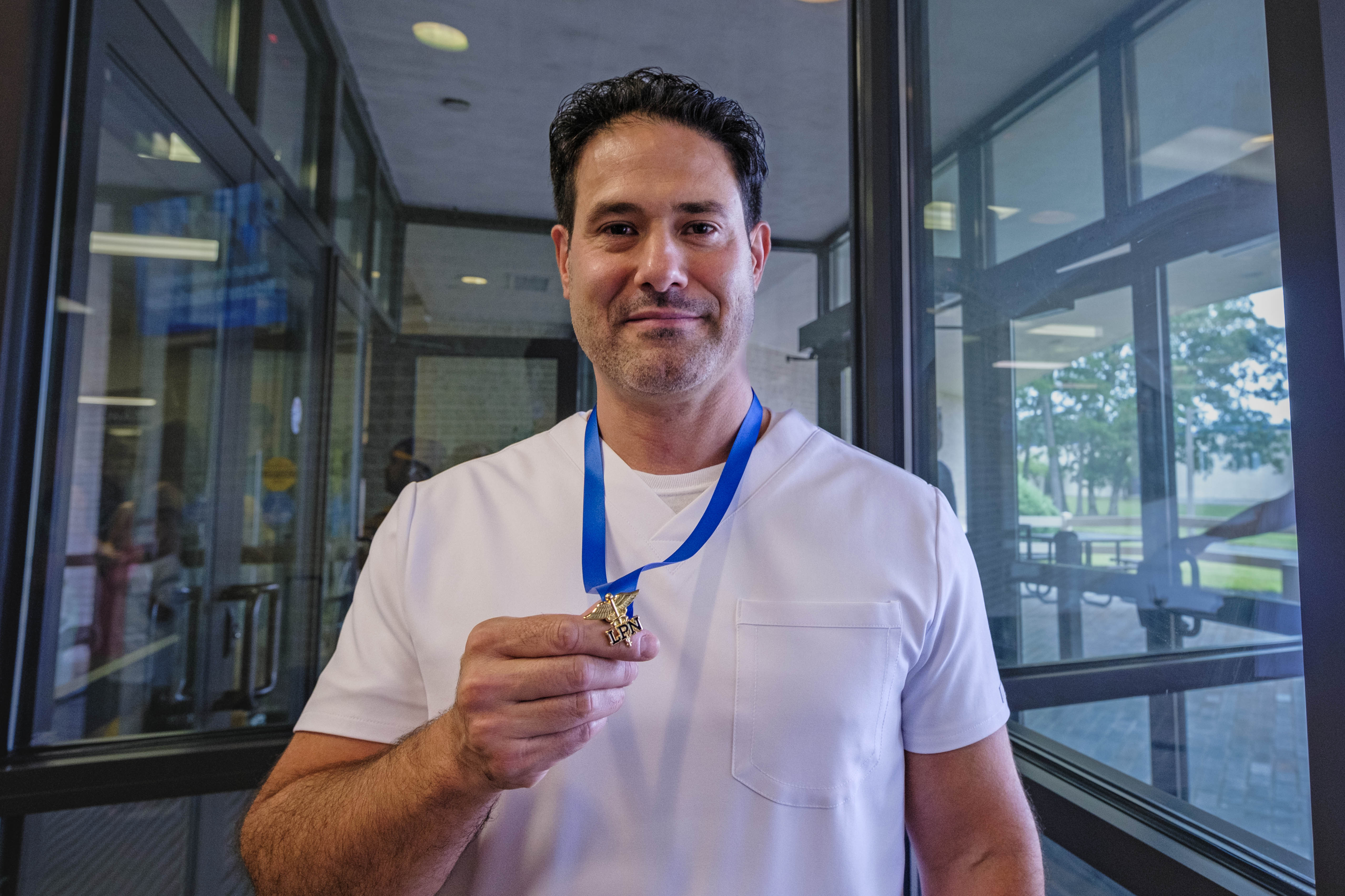 Graduate Daniel Simone shows off his pin