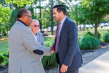 Dr. Abreu is greeted by Board Chairman Trustee Daniel Money and Trustee Donald Parker
