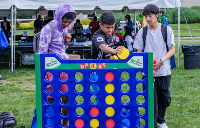 three students playing connect four