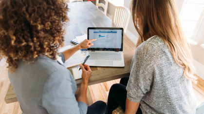 parent looking at a computer with daughter