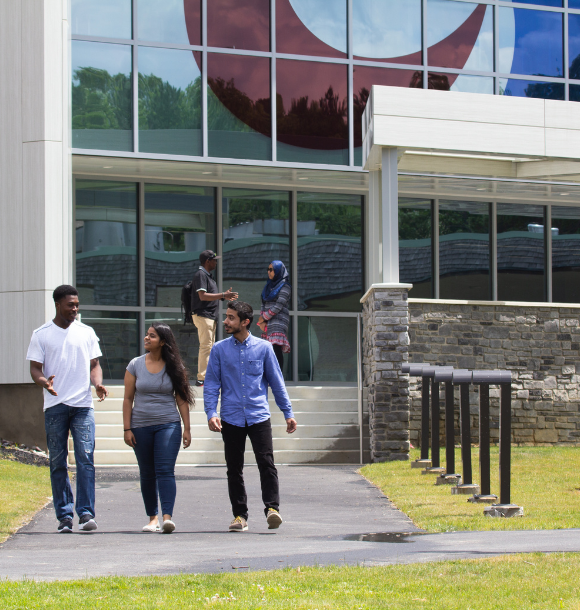 three-students-talking-outside-g-building.png