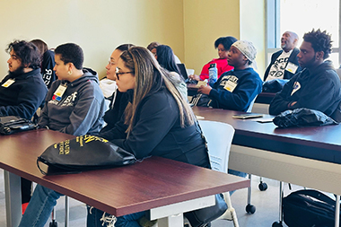 Students in a classroom taking notes and listening to the instructor