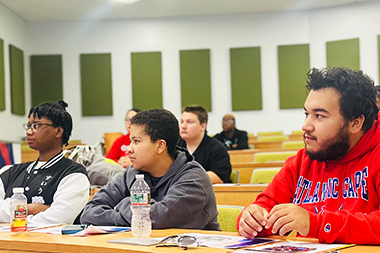 Students in a lecture hall listening to a presentation
