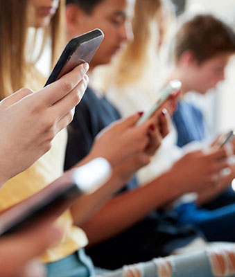 three people on holding their phones