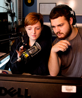 students speaking into a recording microphone