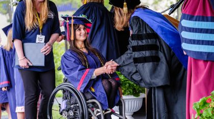 student in wheelchair receiving her diploma