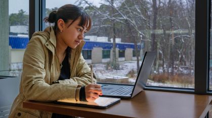 student looking at her computer in the winter
