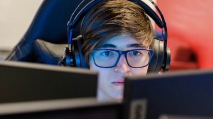male student looking at two computer screens