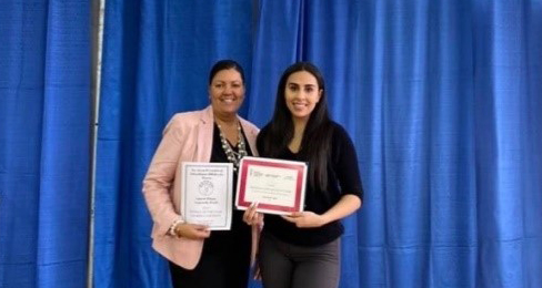 Idalis Santanta accepting her award with Lisa Givens