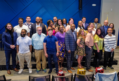 Apex cohort graduates gather for a group photo after the graduation ceremony