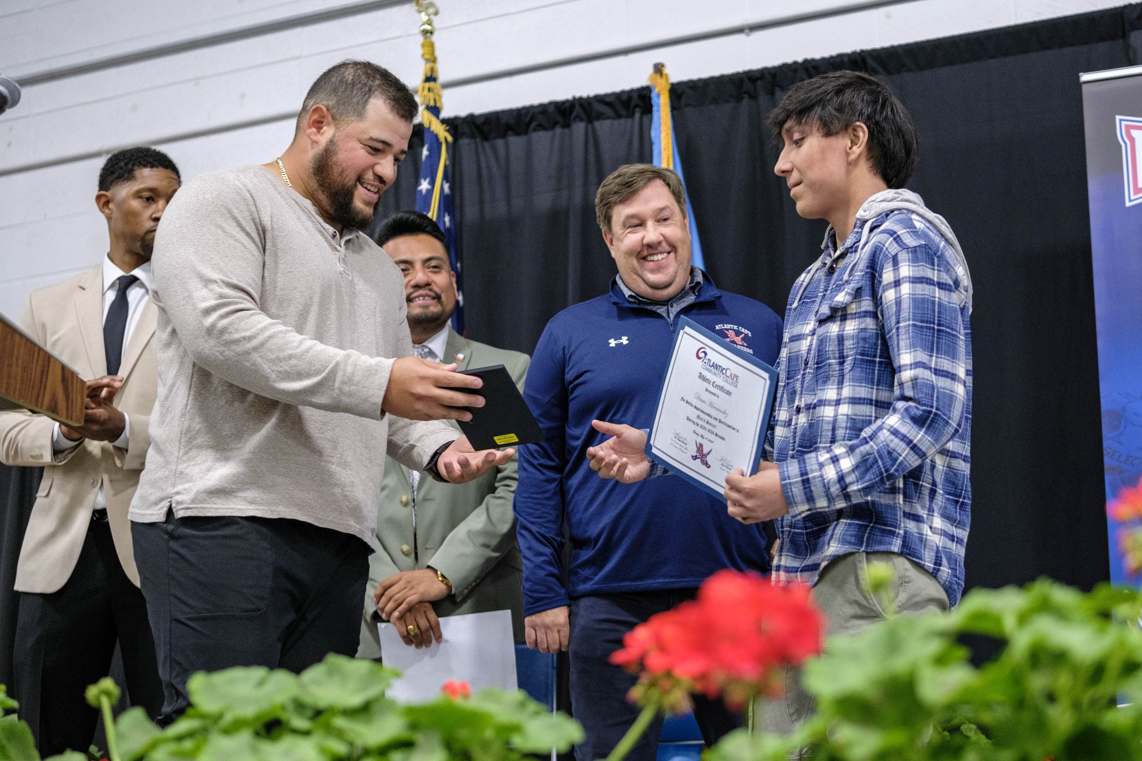 Men's soccer player receives his award from head coach Luis Paz