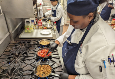 Culinary student cooking her team's dish