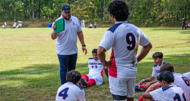 Head Coach Luis Paz speaks with his Men's Soccer players during halftime