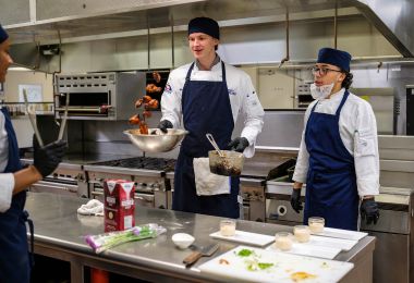 ACA student William Fence tossing wings in their sauce