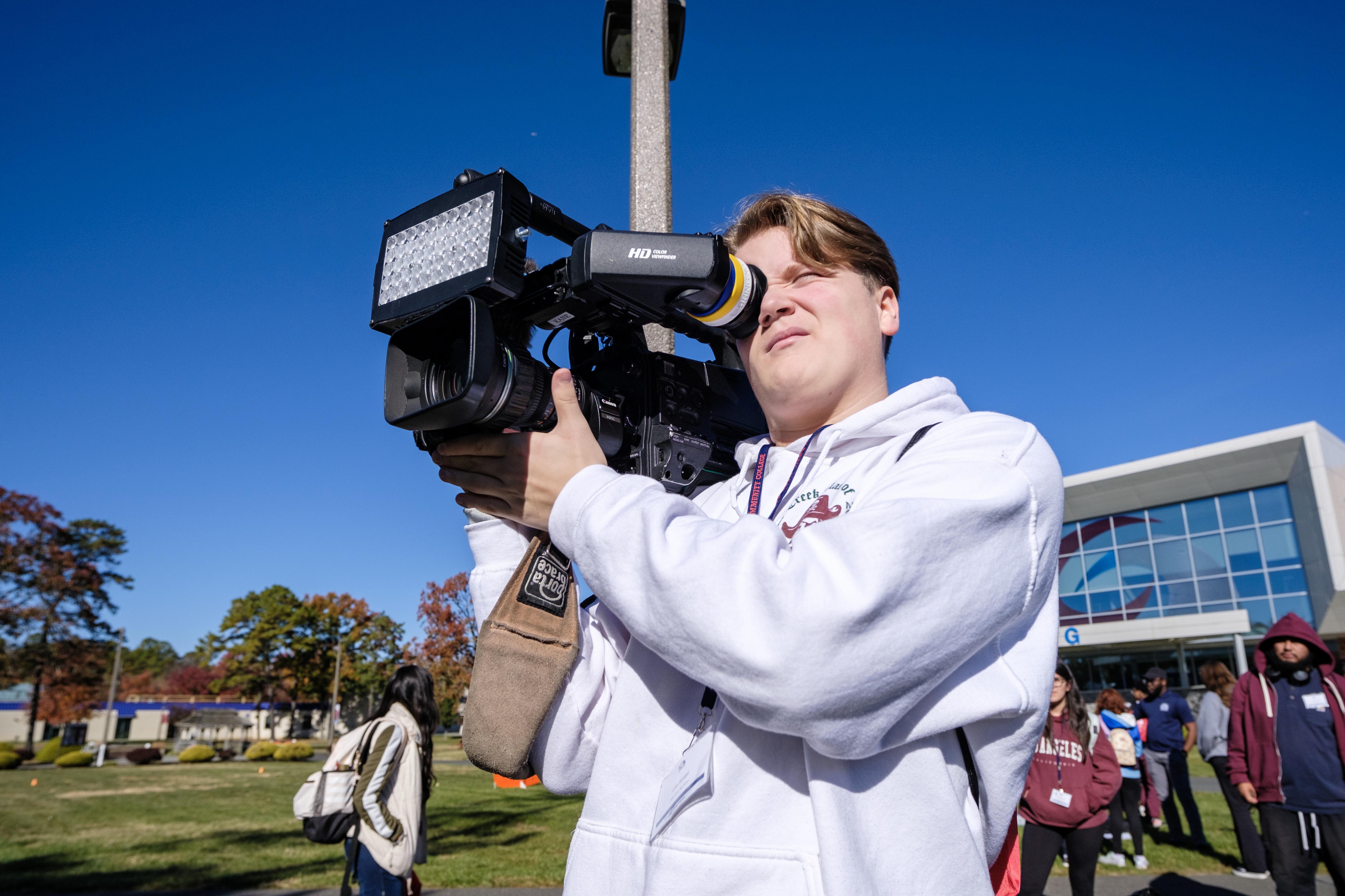 Student tries working a television camera at Media Day