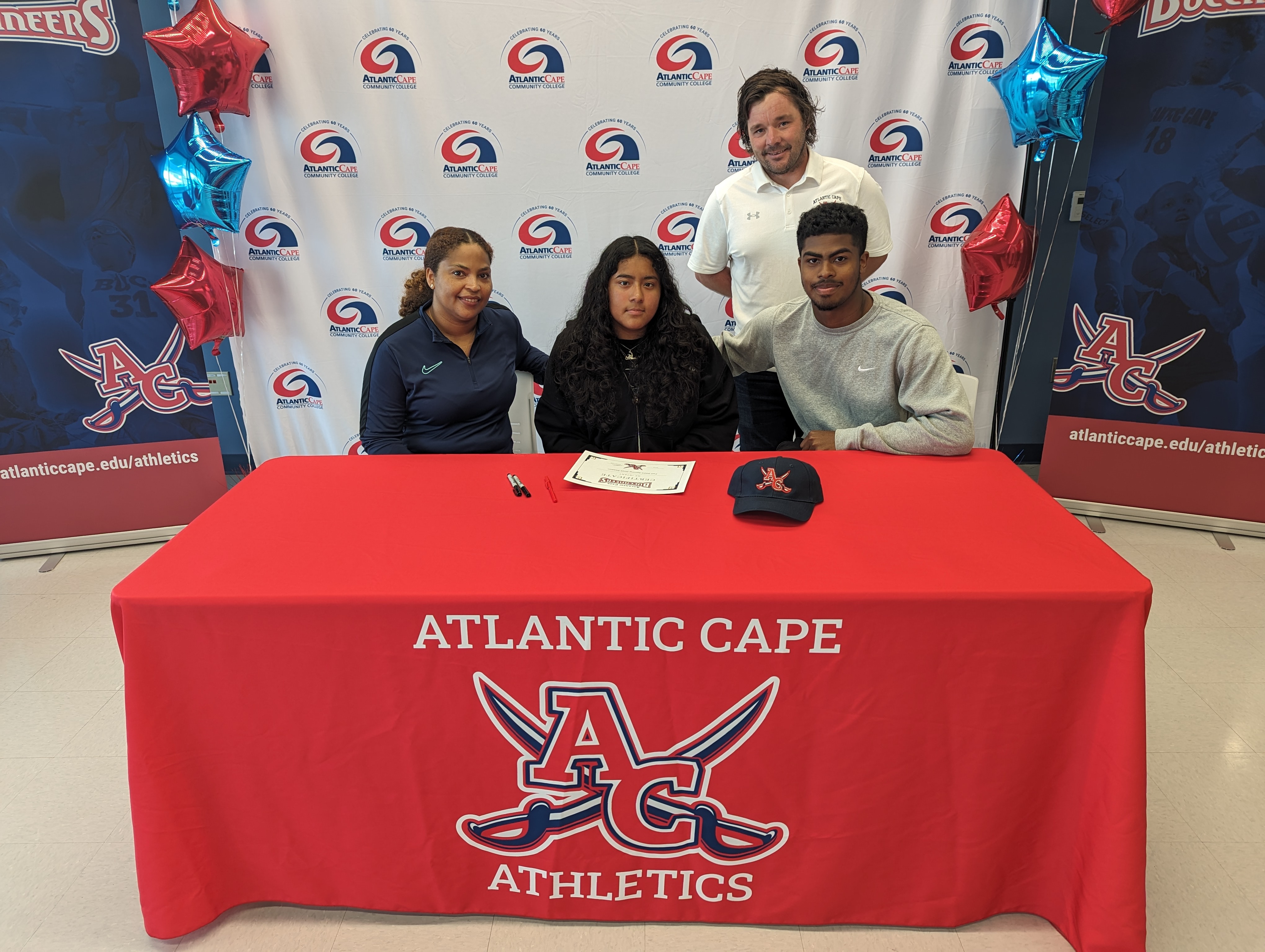 a new women's soccer player and her family with head coach Wesley Raywood